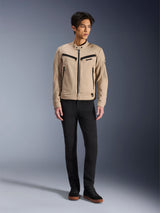 Chaqueta Alpinestars Bruiser, chaqueta urbana de motociclismo en color Aluminum, combinada con pantalones negros y zapatillas negras, con bolsillos negros con cremallera y cuello con botón a presión, diseño contemporáneo inspirado en la ropa de trabajo para conducción urbana