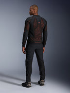 Alpinestars Troop-Air Pro Jacket in Black Red Fluo, rear view on a model, featuring a large 2D tech mesh back panel with visible red interior, paired with black technical riding pants and black/grey boots, modern urban armored motorcycle jacket design.