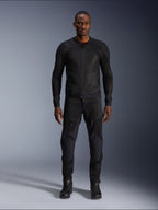Modelo masculino vistiendo la chaqueta Alpinestars Troop-Air en color Black Black, chaqueta de moto de malla ligera, combinada con pantalones y botas de montar negros a juego, con una construcción técnica de malla 2D para un flujo de aire superior.
