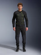 Modelo masculino vistiendo la chaqueta Alpinestars Troop-Air en Negro Amarillo Flúor, con paneles de malla técnica y detalles en amarillo flúor, combinada con pantalones y calzado de motociclismo negros, equipamiento contemporáneo para climas cálidos
