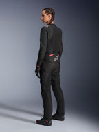 Chaqueta textil de moto Alpinestars Stella T-Sps Air v2 para mujer, negro y rosa diva, vista lateral trasera, con amplios paneles de malla para ventilación y el logo de estrella blanca en la espalda, combinada con pantalones de motociclismo, guantes y botas negras a juego.
