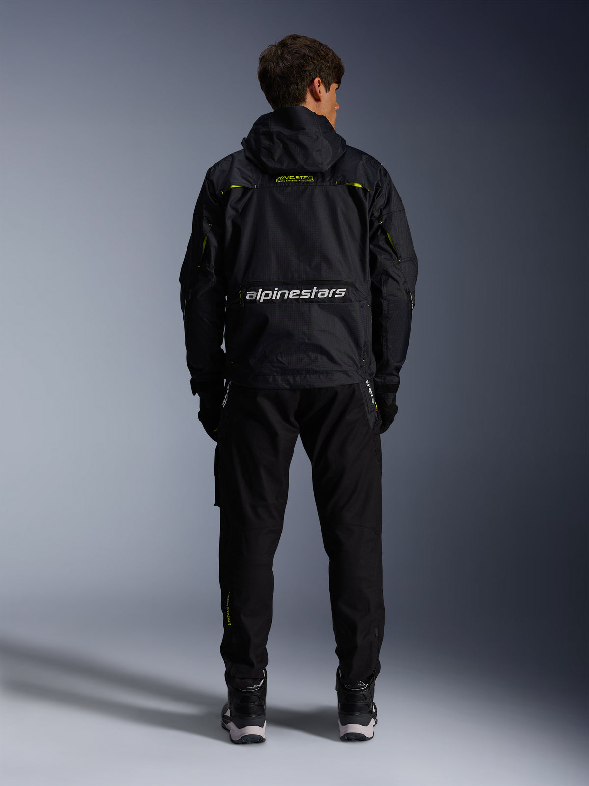 Alpinestars Mogress Air, chaqueta de moto urbana para hombre, negra y verde lima, vista trasera con logotipo blanco.