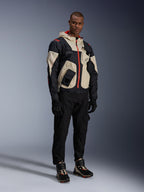Hombre con equipamiento completo de moto urbana, con zapatillas Alpinestars Speedstreet en Black Almond Hot Orange y chaqueta Mogress Air en negro y crema, pantalones y guantes negros a juego, conjunto protector inspirado en el streetwear para la conducción urbana