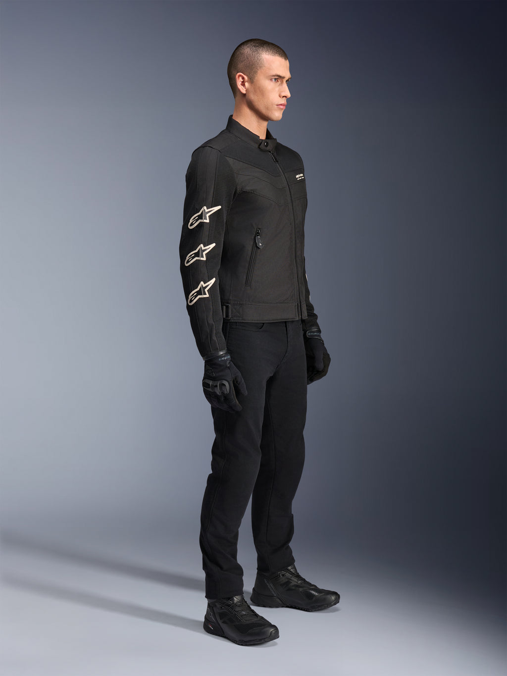 Chaqueta Alpinestars T-Dyno Air, negra, chaqueta textil para motocicleta, con tres logotipos blancos de Alpinestars en la manga, combinada con pantalones y guantes negros a juego, equipamiento de conducción urbana con paneles de malla transpirable