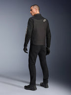 Chaqueta Alpinestars T-Dyno Air, negra, vista posterior de modelo usando una chaqueta de moto textil transpirable, con el logotipo blanco de Alpinestars en el hombro, combinada con pantalones y guantes negros, estilo de conducción urbana