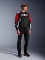 Modelo masculino vistiendo la chaqueta Alpinestars MM93 T-SPS Air v2 en negro, rojo brillante y blanco, con logotipos MM93 destacados en el pecho y las mangas, combinada con pantalones negros y botas de moto; estilo urbano deportivo con paneles de malla visibles para el flujo de aire.