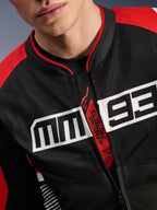 Chaqueta Alpinestars MM93 T-SPS Air V2, chaqueta de moto, negro, rojo brillante y blanco, primer plano del pecho con un gran logotipo MM93 en blanco, tirador de cremallera rojo con 'Alpinestars Protects' y 'Tech-Air Ready', textura de tejido de malla técnica
