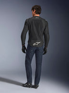 Alpinestars FQ20 T-SPS Air V2 Monster Jacket, Black, rear view on model wearing dark blue jeans and black riding boots, featuring a large white logo on the lower back and breathable mesh panels, urban sport riding gear
