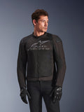 Chaqueta Alpinestars SMX Air en Black Anthracite, chaqueta textil de moto con paneles de malla de alto flujo, presenta un gran logotipo y texto de Alpinestars en gris en el pecho, deslizadores de hombro DFS Lite, usada por un modelo con guantes de conducción negros, estilo de conducción deportiva.