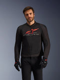 Chaqueta Alpinestars SMX Air, chaqueta de motociclismo deportiva y de carreras, negra con detalles en rojo brillante y blanco, con un gran logotipo rojo y marca en blanco en el pecho, construcción de malla técnica para ventilación, usada por un modelo con guantes y pantalones de conducción negros.