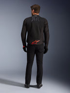 Chaqueta Alpinestars SMX Air, negra con logo en rojo brillante, vista trasera que muestra la marca Tech-Air Ready y paneles de ventilación de malla, combinada con pantalones y guantes negros, equipamiento de alto rendimiento para motociclismo deportivo y de carreras