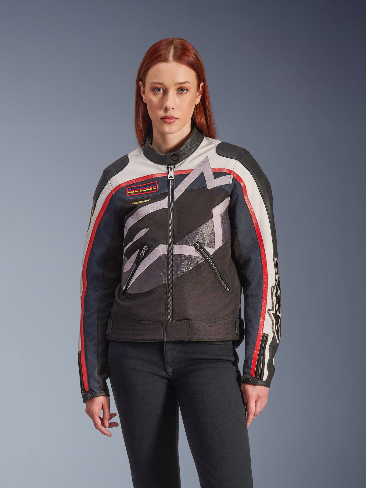 Alpinestars Idles Jacket, chaqueta de moto unisex, negra con patrones en blanco, rojo y gris, rayas rojas y blancas en las mangas, cuello alto, bolsillos con cremallera, diseño gráfico audaz