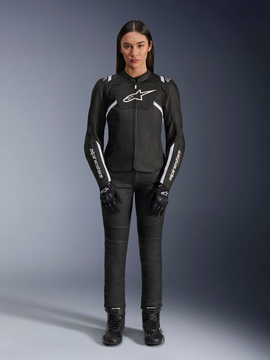 Chaqueta Alpinestars Stella T-Sps Air V2, chaqueta de moto para mujer, negra y blanca, con paneles de malla y detalles blancos, usada con pantalones, guantes y botas negros, ajuste deportivo para conducción urbana
