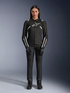 Chaqueta Alpinestars Stella T-Sps Air V2, chaqueta de moto para mujer, negra y blanca, con paneles de malla y detalles blancos, usada con pantalones, guantes y botas negros, ajuste deportivo para conducción urbana