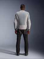 Chaqueta Alpinestars C-1 Air en color plata, vista desde atrás en un modelo masculino, chaqueta de moto de tejido técnico con amplios paneles de ventilación de malla técnica, pequeño logotipo negro en el cuello y ajustadores de cintura, combinada con pantalones de conducción negros para un estilo urbano contemporáneo.