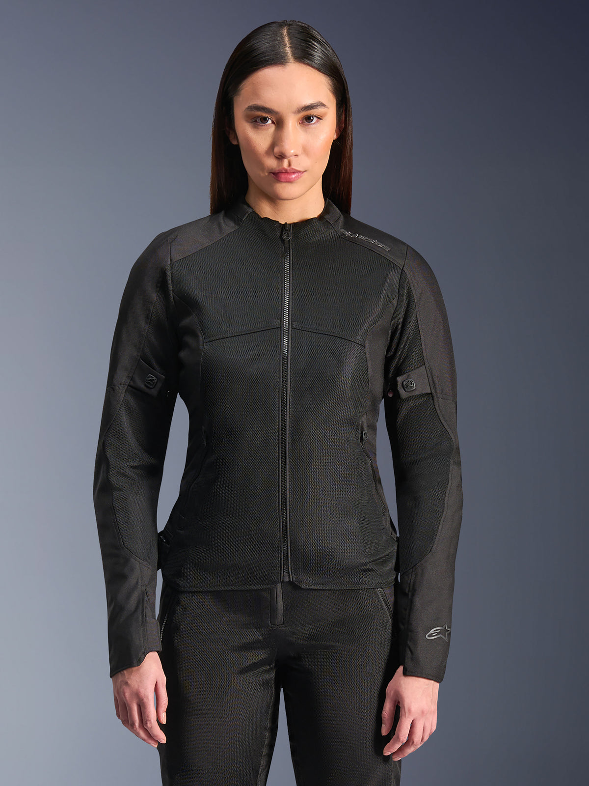 Alpinestars Stella C-1 Air Jacket, chaqueta de moto para mujer, negra, modelo luciendo una elegante chaqueta con cremallera y paneles de malla técnica, diseño ajustado con sutiles logotipos reflectantes en el hombro y el puño de la manga