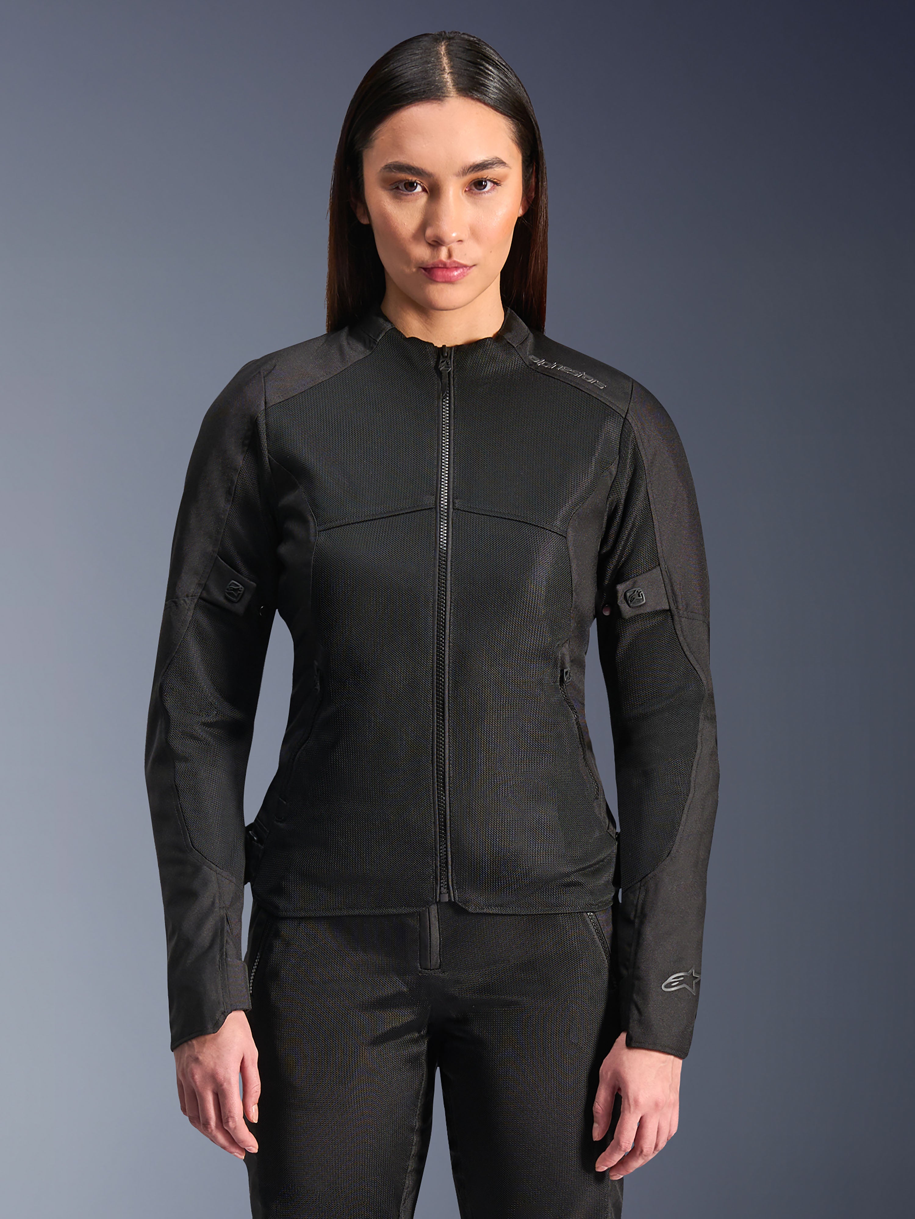 Alpinestars Stella C-1 Air Jacket, chaqueta de moto para mujer, negra, modelo luciendo una elegante chaqueta con cremallera y paneles de malla técnica, diseño ajustado con sutiles logotipos reflectantes en el hombro y el puño de la manga