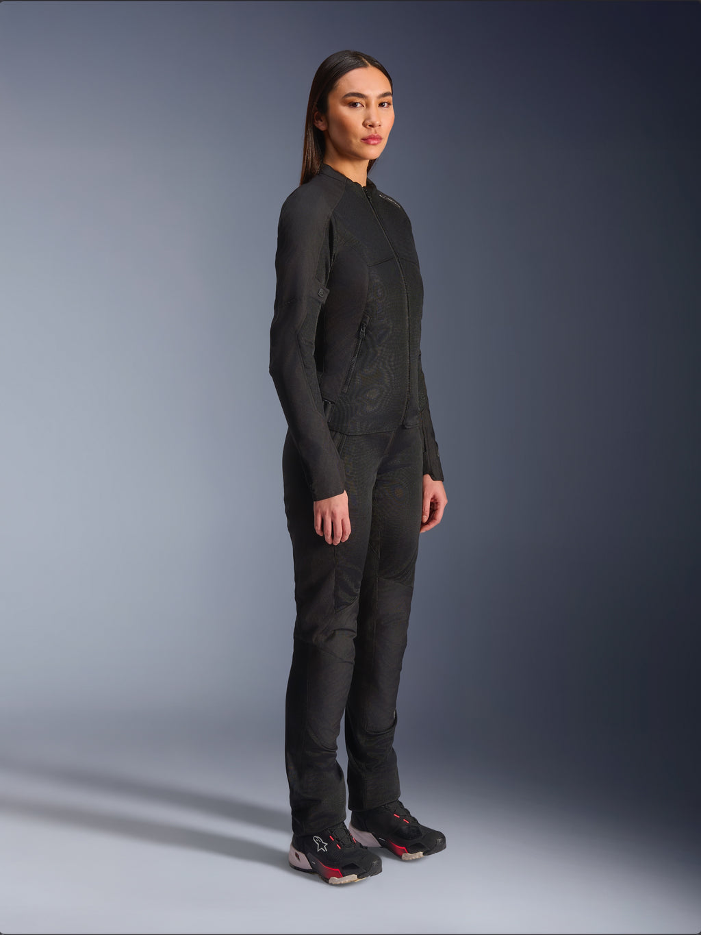 Chaqueta Alpinestars Stella C-1 Air para mujer en color negro, chaqueta textil de moto con paneles de malla, combinada con pantalones de conducción negros a juego y zapatillas técnicas, foto de estudio que muestra un conjunto completo de equipamiento para conducción urbana.