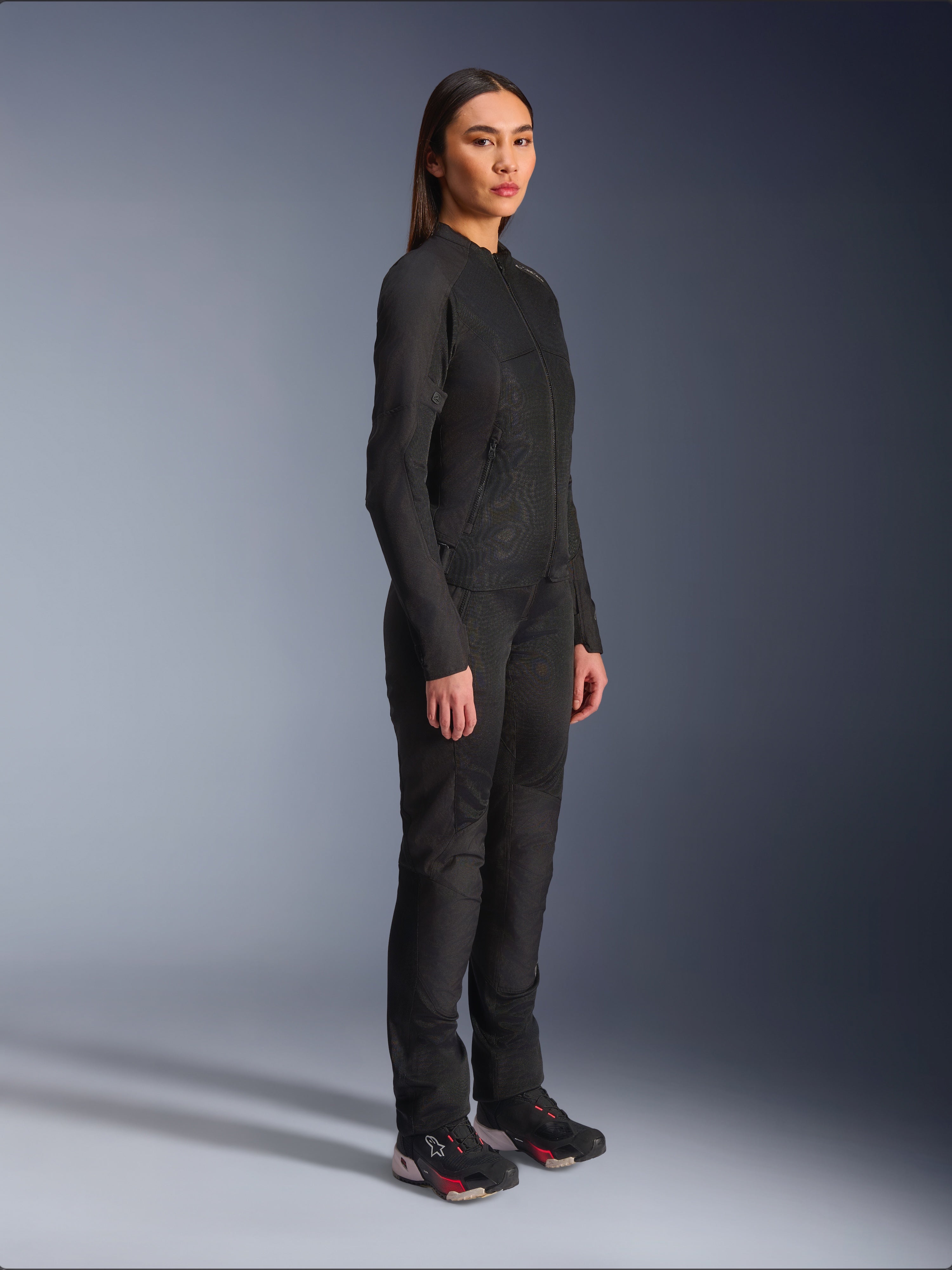 Chaqueta Alpinestars Stella C-1 Air para mujer en color negro, chaqueta textil de moto con paneles de malla, combinada con pantalones de conducción negros a juego y zapatillas técnicas, foto de estudio que muestra un conjunto completo de equipamiento para conducción urbana.