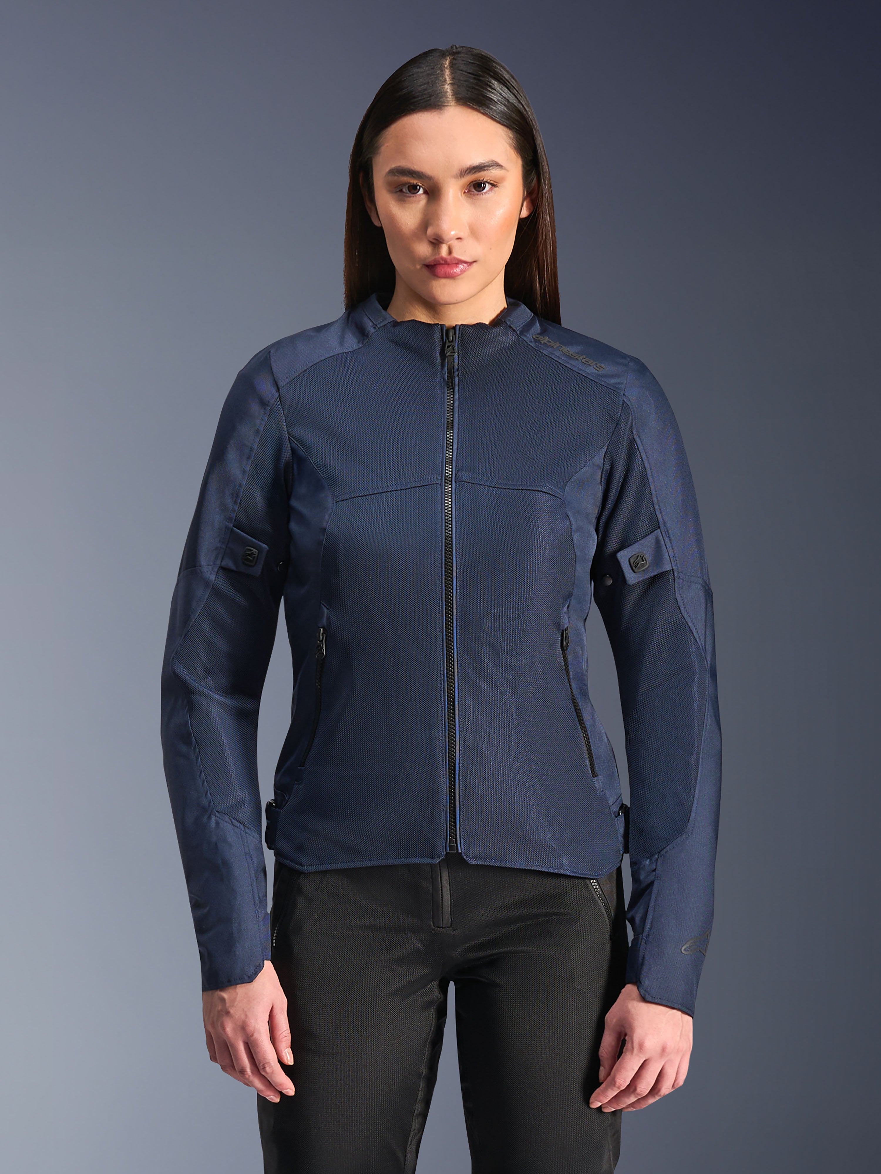 Alpinestars Stella C-1 Air Jacket en azul, chaqueta de moto para mujer, modelada con pantalones de motociclista negros, cuenta con grandes paneles de malla para el flujo de aire, bolsillos frontales y laterales con cremallera y un diseño contemporáneo y limpio.