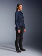 Mujer vistiendo la chaqueta Alpinestars Stella C-1 Air en azul, chaqueta de moto urbana con paneles de malla ligeros para ventilación, combinada con pantalones de motociclista negros y calzado técnico, con un perfil estilizado y logotipos refinados, vista lateral en estudio