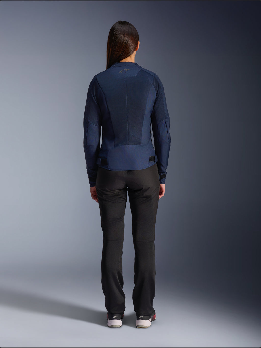 Chaqueta Alpinestars Stella C-1 Air, chaqueta de moto textil para mujer, azul marino, vista trasera con amplios paneles de malla para ventilación y logotipo de Alpinestars en el cuello, combinada con pantalones de moto negros para un estilo urbano moderno