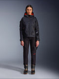 Pantalones Alpinestars Actea para mujer, pantalones de moto negros con detalles de texto en rojo y bolsillos cargo, usados por una motorista con una chaqueta negra con capucha, ropa de moto urbana moderna