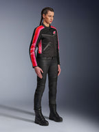 Chaqueta Alpinestars Stella T-Dyno Air, chaqueta de moto para mujer, negra con franjas rojo brillante y fucsia en las mangas, combinada con pantalones de motociclismo y botas en color negro, diseño de malla de inspiración vintage para conducción urbana