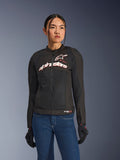Mujer con chaqueta Alpinestars Stella SMX Air, negro, blanco y rojo flúor, chaqueta de moto textil con malla ventilada y logotipo blanco en el pecho, combinada con vaqueros azules y guantes de moto negros, ajuste femenino para conducción deportiva