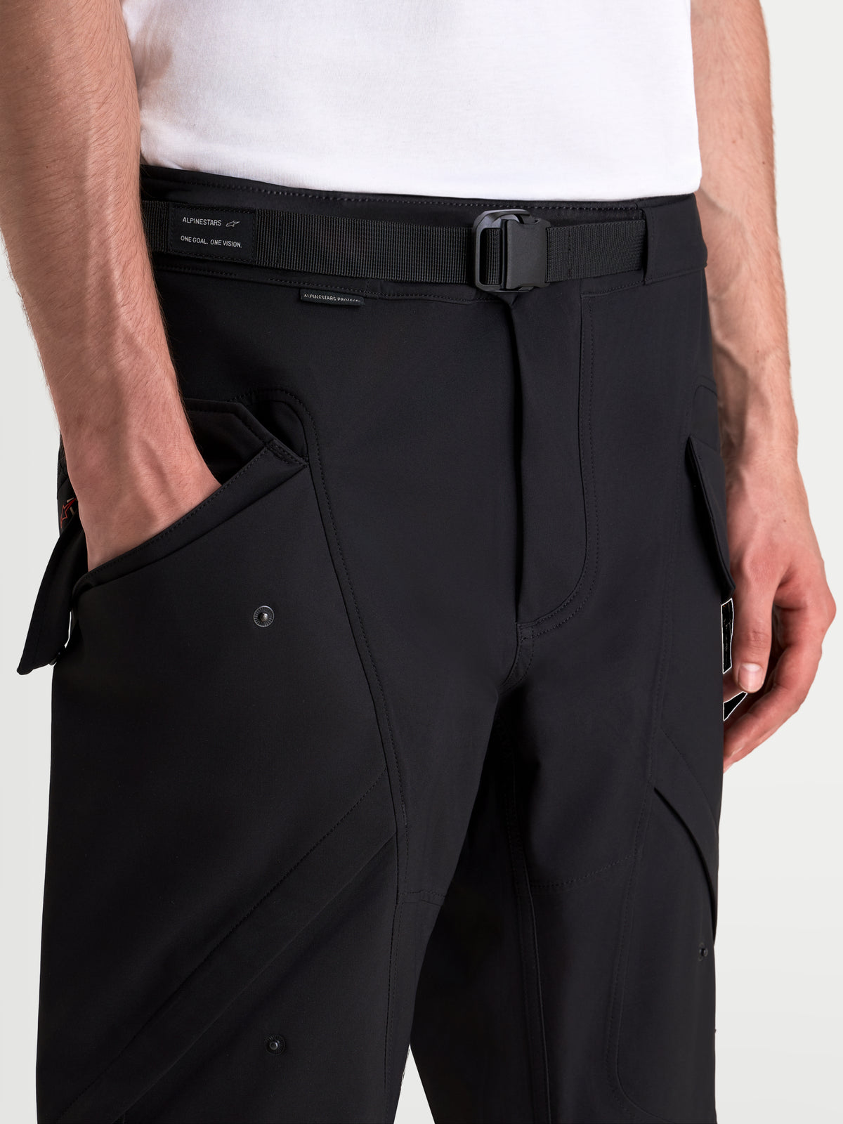 Alpinestars Juggernaut V 2 Drystar Pantalones, pantalones de moto urbanos, negros, en primer plano con cinturón ajustable, hebilla magnética y bolsillos cargo delanteros en modelo