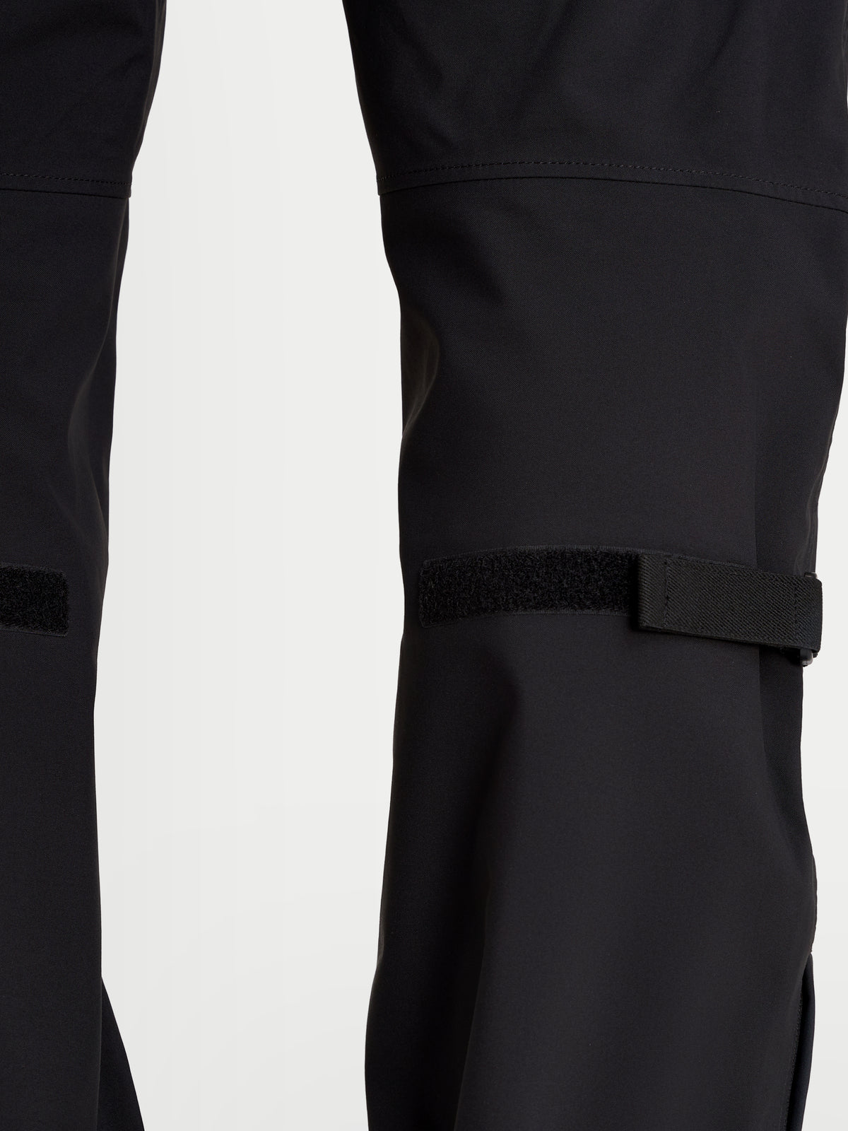 Alpinestars Juggernaut V2 Drystar Pantalones, pantalones de moto urbanos impermeables para hombre, negros, vista en primer plano de los ajustadores de la parte inferior de la pierna y construcción de tejido técnico