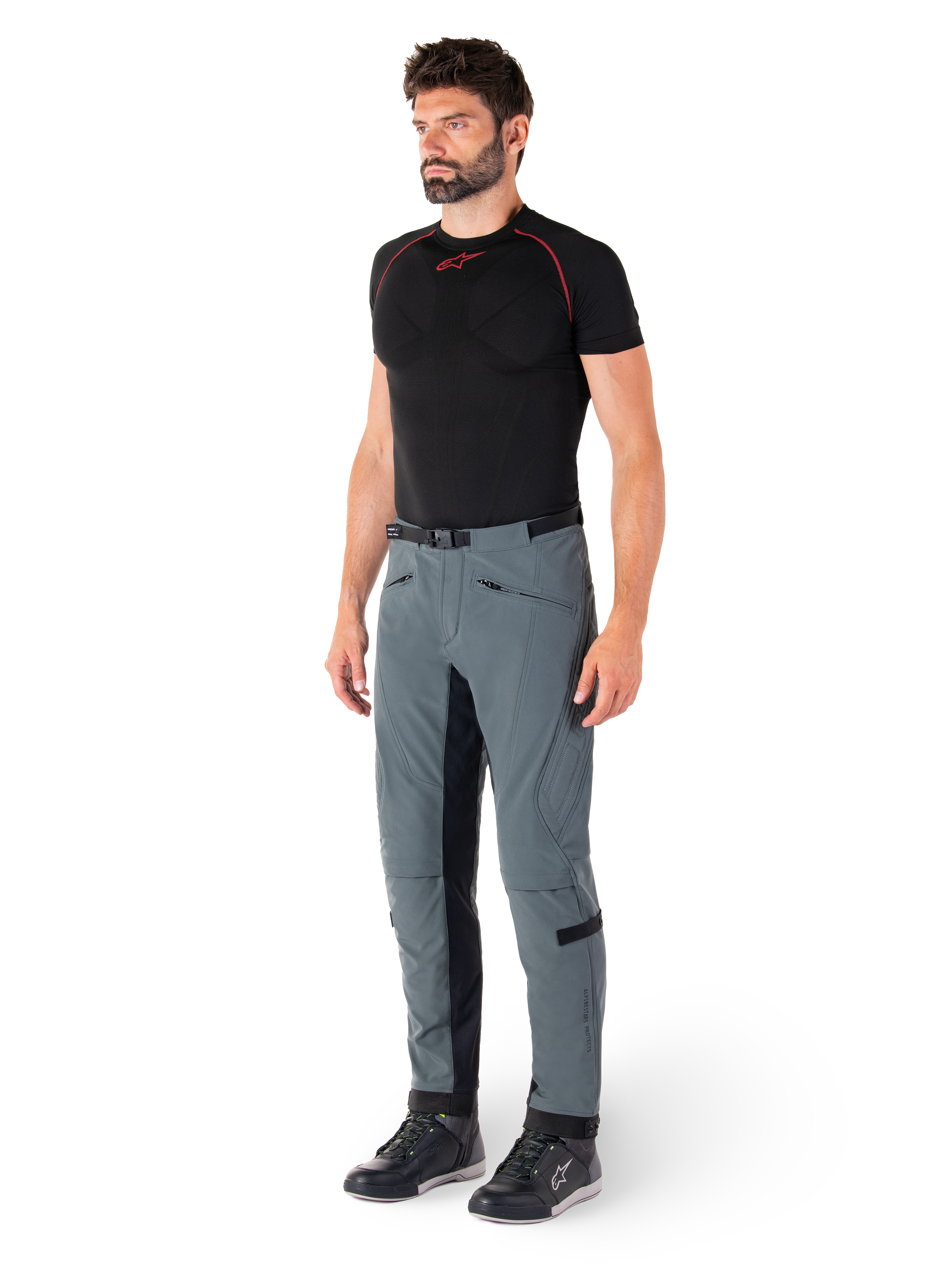Pantalones Alpinestars Alden, pantalones técnicos de motociclismo en color Urban Gray, con paneles laterales acolchados y tejido elástico negro en el interior de la pierna, combinados con una capa base negra y calzado de conducción, equipamiento de conducción urbana inspirado en el estilo streetwear