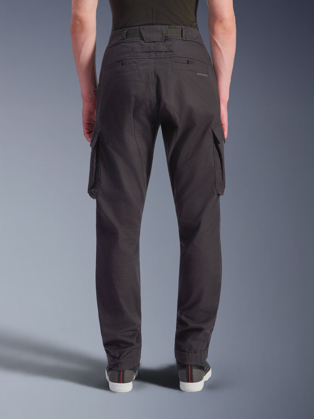 Alpinestars Flex-AST Cargo Pants - Short, Urban Motorcycle Pants, Black, back view showing a regular tapered fit with elasticated hems, large side cargo pockets, and subtle branding on the back pocket, worn with casual sneakers