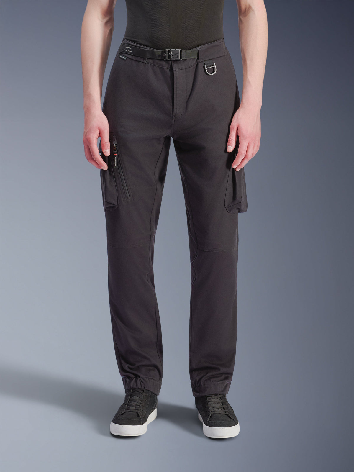 Alpinestars Flex-AST Cargo Pants, Motorcycle Pants, Black, front view showing regular tapered fit, cargo pockets, integrated belt with D-ring, and elasticated hems, paired with black sneakers