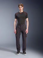 Pantalones Cargo Alpinestars Flex-AST, negros, pantalones de moto urbanos llevados por un modelo masculino con una parte superior negra de manga corta y zapatillas, con un ajuste regular ahusado, bolsillos cargo y detalle de hebilla de cinturón integrada