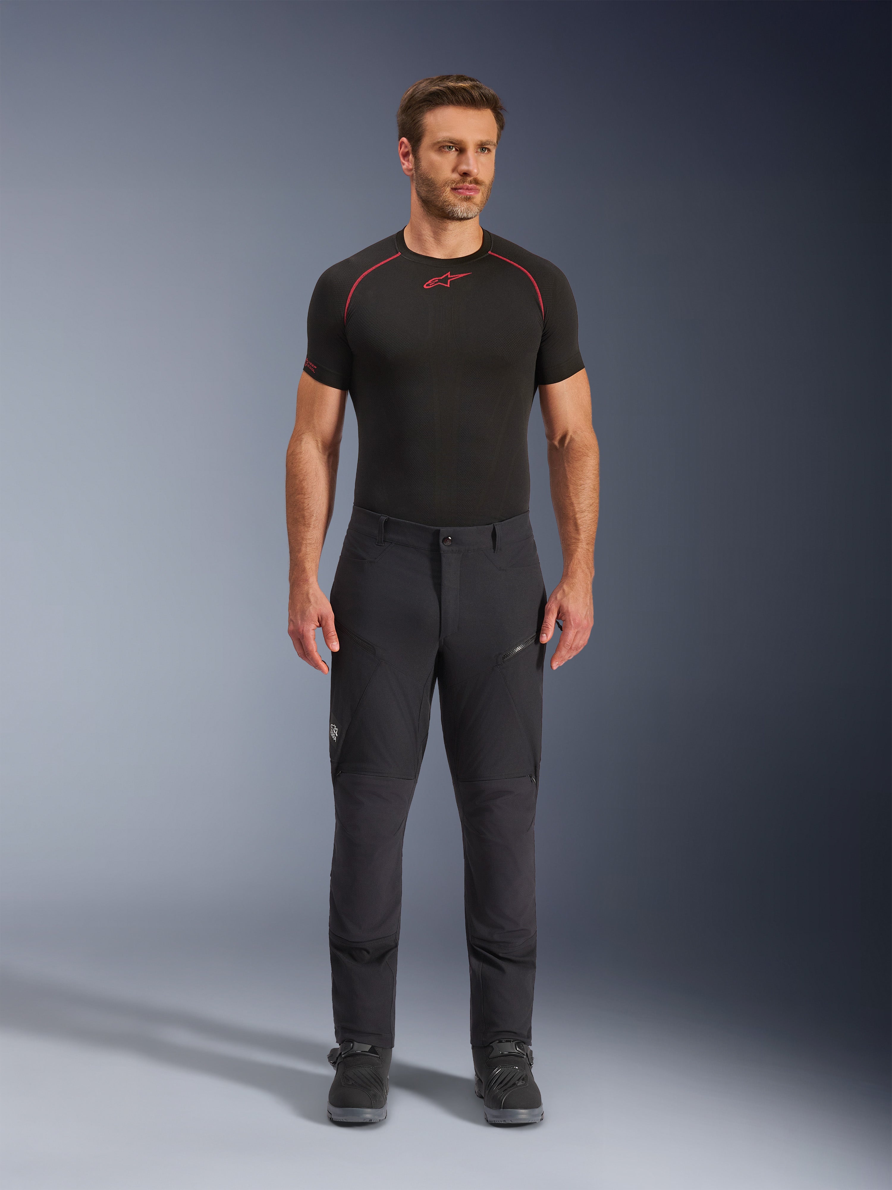 Alpinestars Flex-AST Explorer Pants, pantalones de moto adventure touring negros, hombre con pantalones de conducción textiles ajustados con bolsillos cargo con cremallera y paneles reforzados, combinados con una capa base negra y botas de moto, protección duradera para conducción adventure