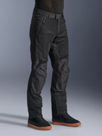 Alpinestars C-1 Air Pants, pantalones urbanos de moto, negros, con paneles de malla técnica transpirable y construcción en polifabric, usados con zapatillas negras, diseño limpio y funcional para la conducción urbana.