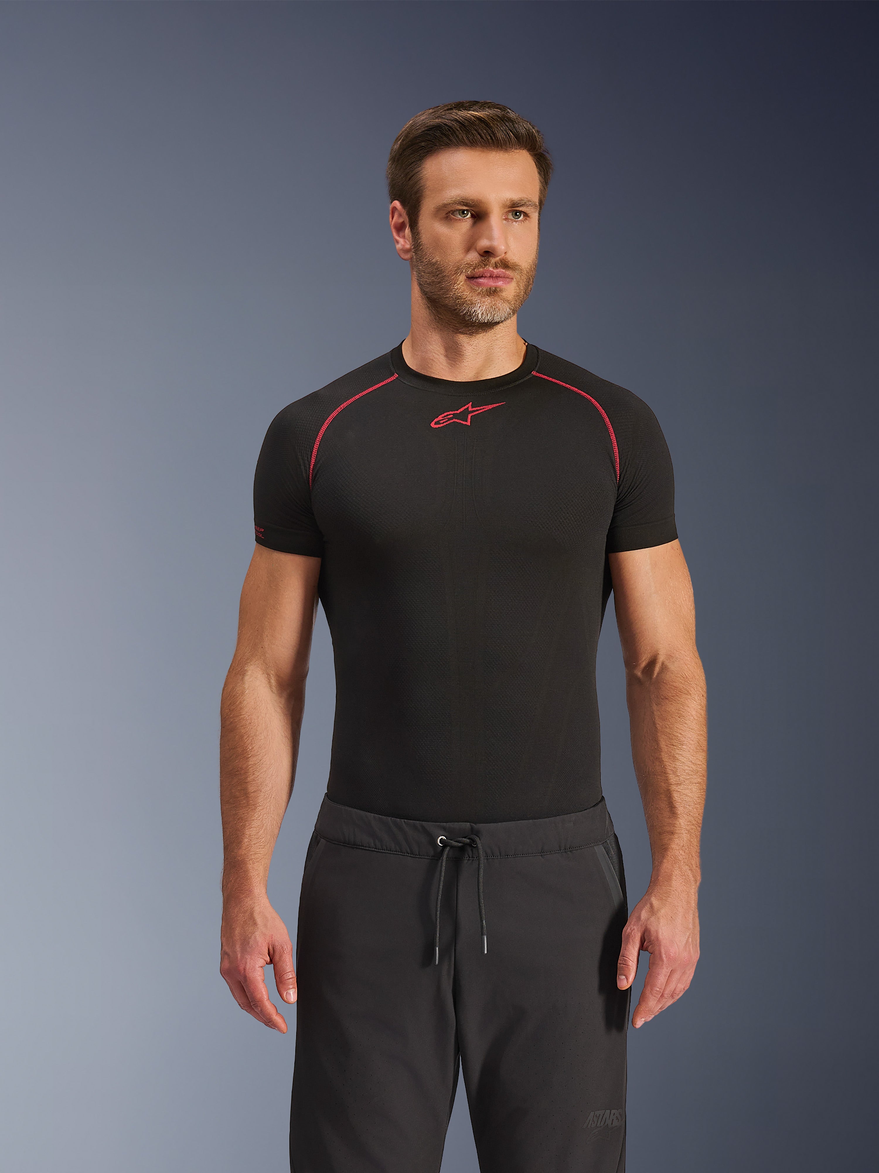 Pantalones Alpinestars Aeroshell Airflow, pantalones de moto negros, tejido softshell ligero, con cintura con cordón y ventilación perforada con láser, usados con una camiseta de capa base Alpinestars negra