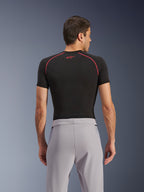 Pantalones Alpinestars Aeroshell Airflow, Gris Medio, vista trasera, combinados con una capa base de manga corta negra con costuras y logotipo rojos, con tejido softshell elástico ligero y paneles de malla para una ventilación máxima, ajuste deportivo ergonómico para la conducción de motocicletas