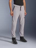 Pantalones Alpinestars Aeroshell Airflow, Gris Medio, pantalones de moto ligeros con zonas de ventilación perforadas con láser en los muslos y las espinillas, cuentan con una cintura elástica con cordón y un ajuste deportivo entallado, mostrados en un modelo con calzado de moto negro.