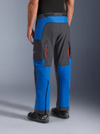 Alpinestars Maxdura Dual Pants, azul real y gris oscuro, vista trasera que muestra bolsillos con cremallera y zonas de ventilación, diseño sobre la bota usado con botas Alpinestars negras, equipamiento duradero para conducción de aventura y dual-sport