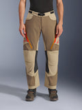 Pantalones Alpinestars Maxdura Dual, Walnut Aluminum, pantalones de moto de aventura con ventilaciones en los muslos con cremalleras rojas y naranjas, paneles interiores de cuero negro en las rodillas, usados con una capa base negra y botas robustas, diseño multitonal duradero para conducción dual-sport