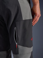 Pantalones Alpinestars Maxdura Dual, pantalones de motociclismo de aventura en gris oscuro y gris profundo, primer plano del muslo con ventilación con cremallera y logotipo bordado en rojo, construcción de poliamida elástica duradera.