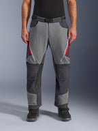 Alpinestars Maxdura Dual Pants, pantalones de aventura para moto, gris oscuro y gris intenso con detalles rojos, vista frontal que muestra ventilaciones con cremallera en los muslos, cinturón con hebilla magnética y paneles reforzados en las rodillas, diseño sobre la bota para conducción dual-sport.
