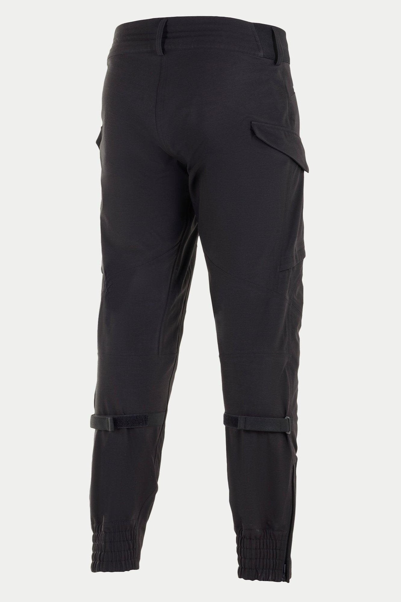 Pantalones Alpinestars Juggernaut Waterproof, pantalones de moto negros, vista trasera con puños elásticos en los tobillos, ajustadores de volumen en la pantorrilla y bolsillos cargo, construcción softshell 3L para conducción urbana y en carretera