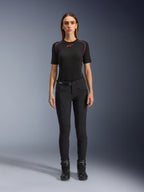 Pantalones Alpinestars Alamosa para mujer, pantalones de moto negros de ajuste ceñido, mostrados en una modelo de frente, con bolsillos delanteros con cremallera y cinturón integrado, estilo minimalista inspirado en el streetwear para conducción urbana