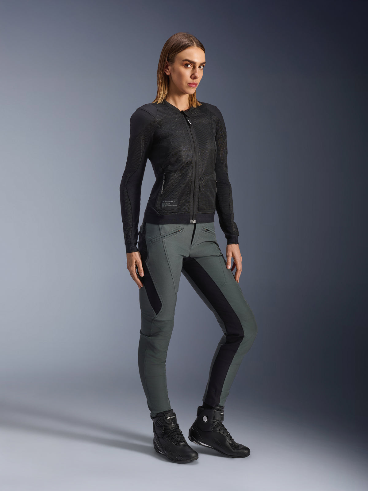 Alpinestars pantalones Alamosa para mujer, gris urbano y negro, textil de moto, ajuste slim, con chaqueta y botas negras.