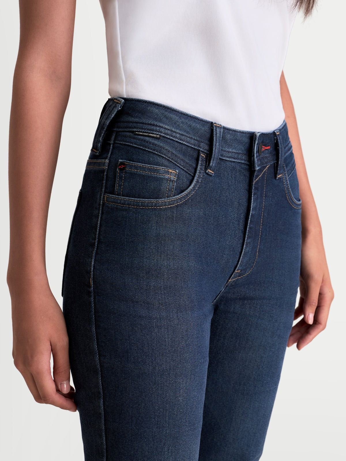 Alpinestars Stella Flex-AST 7 Denim Pants, women's urban motorcycle riding jeans, dark blue, close-up view of the waist and pocket construction worn by a model