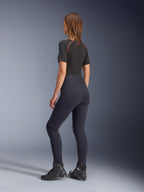 Alpinestars Woman Stella Flex-AST Leggings, black high-waisted motorcycle leggings, back view showing skinny fit and back pockets, worn with black short-sleeve top and motorcycle boots, urban riding gear for women.