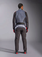 Alpinestars KMX-9 V3 Graphic 6 Suit, mono de karting, negro antracita y rojo, vista trasera que muestra un gran logotipo blanco de Alpinestars en la parte baja de la espalda, parte superior del cuerpo gris con gráficos de salpicaduras negras, brazos y piernas negros, usado con guantes y botas de carreras en rojo y negro.